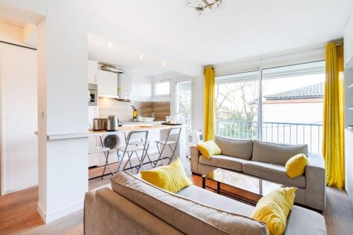 un salon avec deux canapés et une cuisine dans l'établissement 1 bedroom/clim/wifi, St Michel station, à Toulouse