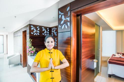 a woman in a yellow shirt standing in front of a door at Howard Johnson By Wyndham, Hebbal, Bengaluru in Bengaluru