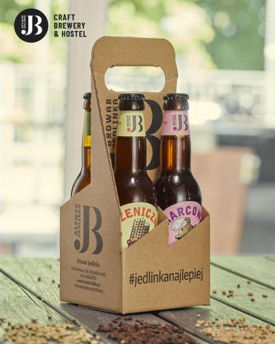 two bottles of beer in a box on a table at Hostel Browar Jedlinka in Jedlina-Zdrój
