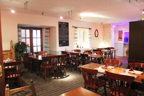 uma sala de jantar com mesas e cadeiras num restaurante em The crown inn Longtown em Hereford
