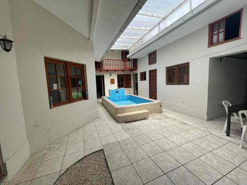 a large room with a swimming pool in a house at Hospedaje Casa Blanca Beach in Los Baños del Inca