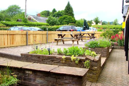 a patio with a picnic table and some plants at The crown inn Longtown in Hereford