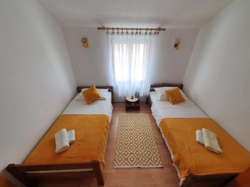 two beds in a small room with a window at Apartment Selak in Šibenik