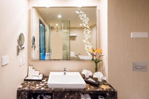 a bathroom with a sink and a large mirror at Howard Johnson By Wyndham, Hebbal, Bengaluru in Bengaluru