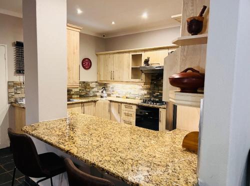 uma cozinha com um balcão de granito e uma ilha de cozinha em Ka~Mo Gae em Louis Trichardt