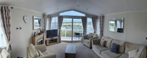 sala de estar con sofá y TV en BEAUTIFUL LUXURY Caravan HAVEN LITTLESEA STUNNING VIEWS Sleeps 6 en Weymouth
