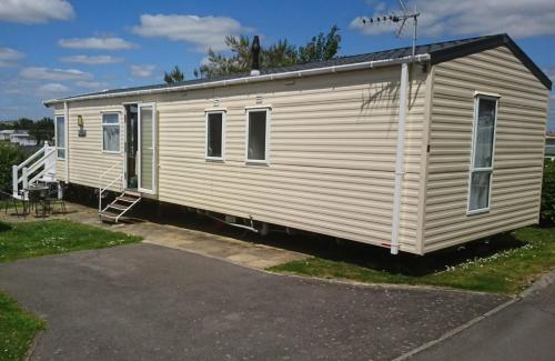 una caravana blanca estacionada en un estacionamiento en BEAUTIFUL LUXURY Caravan HAVEN LITTLESEA STUNNING VIEWS Sleeps 6, en Weymouth