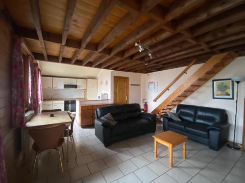 ein Wohnzimmer mit einem Sofa und einem Tisch in der Unterkunft Aux 4 chalets in Bouillon