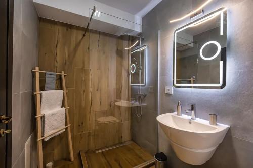 een badkamer met een wastafel en een spiegel bij Modern apartment with city-view near Poiana Brasov in Braşov