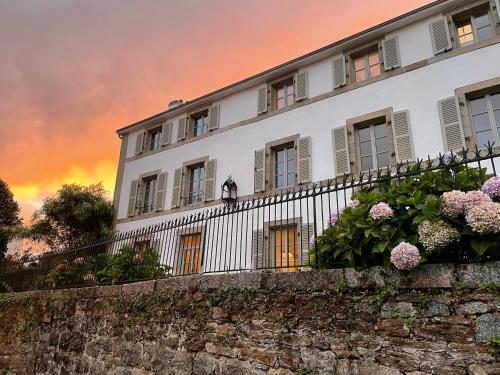 un edificio con una valla y flores en una pared en Kermaria Bois D Amour Apartment en Pont-Aven