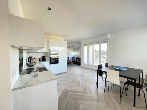 een keuken en eetkamer met een tafel en stoelen bij Proche plage de Royan, vue mer, équipements modernes, confort in Saint-Georges-de-Didonne