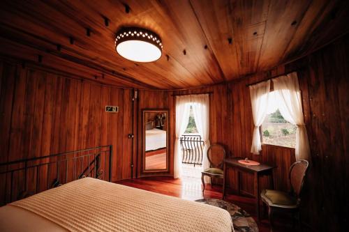 a bedroom with a bed in a wooden room at Pipas Terroir - Vale dos Vinhedos - Pousada Temática in Bento Gonçalves