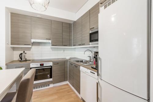 a kitchen with stainless steel appliances and a refrigerator at Helsinki Private-Yksityinen-Частный Room in Shared Apartment into Airport-BusTrain Station-University in Helsinki