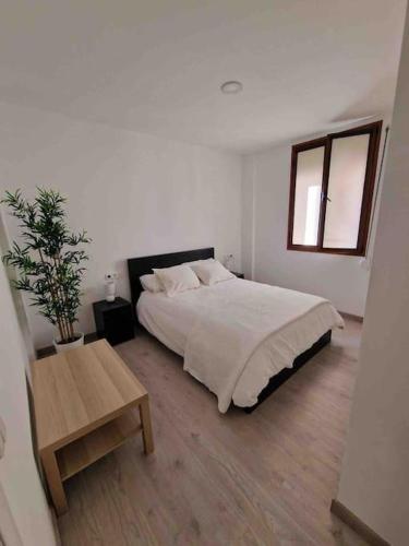 Dormitorio blanco con cama y mesa en Casa María Nieves, en Santa Cruz de la Palma