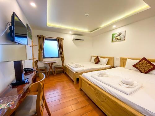 a hotel room with two beds and a television at Khách sạn Vườn Cau & Khu vui chơi giải trí SaLa in Tây Ninh