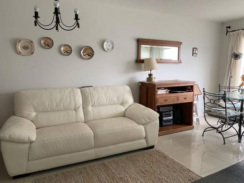 ein Wohnzimmer mit einem weißen Sofa und einem Tisch in der Unterkunft Apto con piscinas, servicios, cochera, wifi in Punta del Este