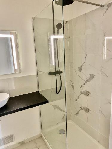 une douche avec une porte vitrée dans une salle de bain dans l'établissement Proche plage de Royan, vue mer, équipements modernes, confort, à Saint-Georges-de-Didonne