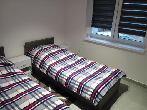 1 Schlafzimmer mit 2 Betten und einem Fenster in der Unterkunft Apartamenty Przy Rynku Gąsawa/Biskupin in Gąsawa