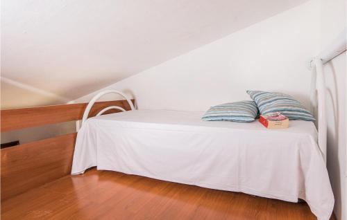 uma cama branca com duas almofadas em cima em Bilo Plus Soppalco em Piombino