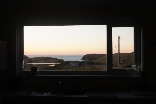 a window in a room looking out at the ocean at No1 Dalbeg, a Hebridean Escape and your Adventure. in Dalebeg