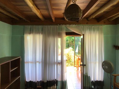 a room with white curtains and a door with at Jodokus Inn in Montezuma