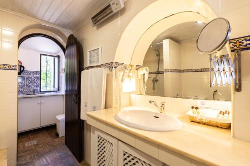 a bathroom with a sink and a mirror at Quinta do Caracol in Tavira