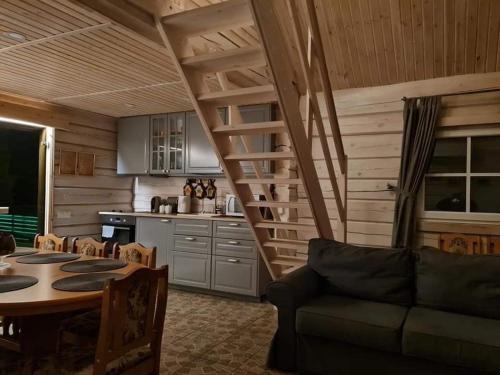 ein Wohnzimmer mit einem Sofa und einem Tisch sowie eine Küche in der Unterkunft Sodybos Narūnas namelis dviems in Jonava