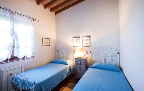 Duas camas num quarto com lençóis azuis e uma janela. em La Piana em Mommio