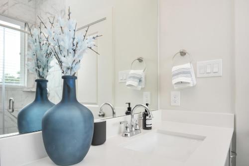 two blue vases sitting on a counter in a bathroom at Casa Azure - New Modern 3 BR, Med Center, NRG, UH in Houston