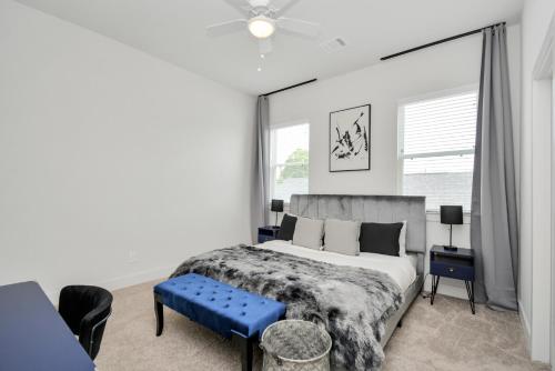 um quarto com uma cama grande e um banco azul em Casa Azure - New Modern 3 BR, Med Center, NRG, UH em Houston