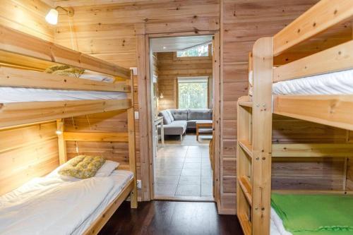 a bedroom with two bunk beds and a living room at Lovely cottage in Koli resort next to a large lake and trails in Kolinkylä