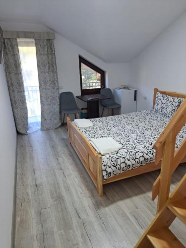 a bedroom with a bed and a table and chairs at Enduro Transalpina in Obarsia-Lotrului