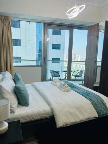 a bedroom with a large bed with a large window at Ocean Heights - Spacious 1 Bedroom Apartment with Sea View, Gym & Free Parking in Dubai