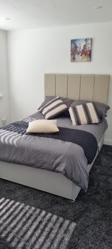 a bedroom with a large bed with pillows on it at Cheerful 3-bedroom home in Sale - free parking on premises in Sale
