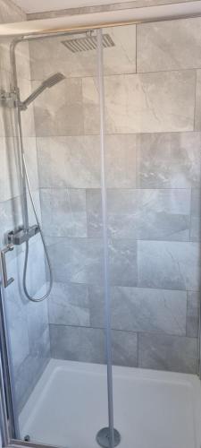 La salle de bains est pourvue d'une douche avec une porte en verre. dans l'établissement Cheerful 3-bedroom home in Sale - free parking on premises, à Sale