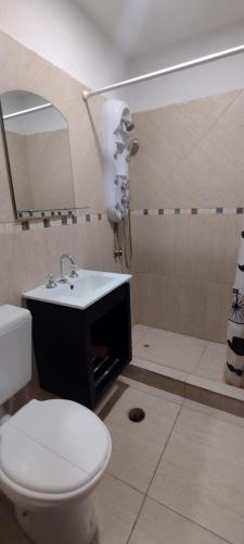 a bathroom with a toilet and a sink at Cabañas El Doral in Potrero de los Funes