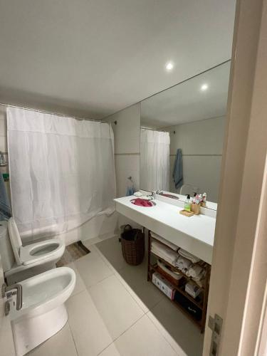 a bathroom with a sink and a toilet and a mirror at Summer Tower 102 in Punta del Este