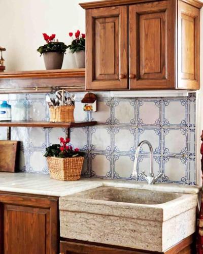 a kitchen with a sink and wooden cabinets at Casa Al Plumbago in Termini Imerese