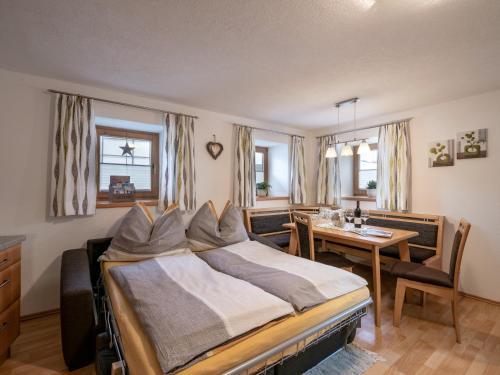 Schlafzimmer mit einem Bett, einem Tisch und Stühlen in der Unterkunft Appartement Stöcklbauer in Westendorf