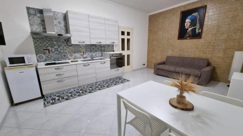 kuchnia i salon ze stołem i kanapą w obiekcie Romano Appartamenti w Trapani