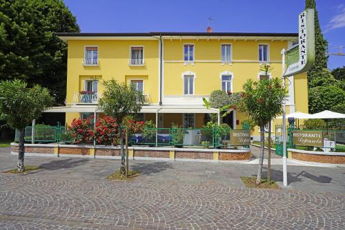 a yellow building with a sign in front of it at Hotel Ristorante Lepanto in Salò