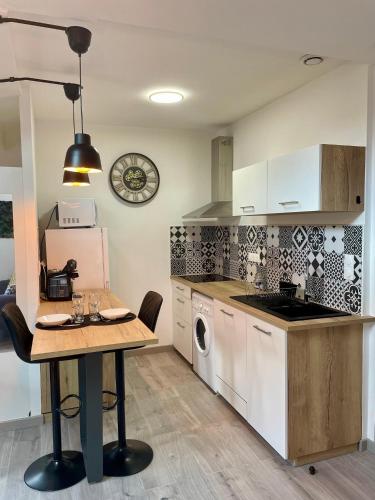 Il comprend une cuisine équipée d'une table et d'une cuisinière. four supérieur dans l'établissement *NOUVEAU*Appartement lumineux centre Blaye, à Blaye