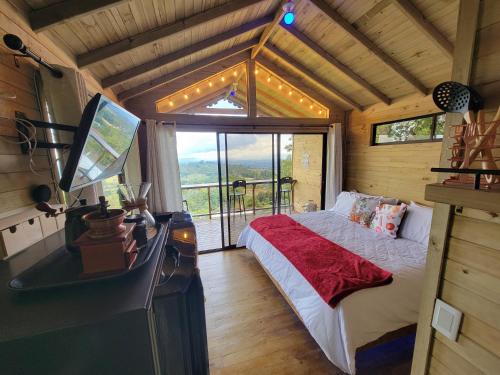ein Schlafzimmer mit einem Bett und einem TV in einer Hütte in der Unterkunft Caralsol Glamping in Rionegro