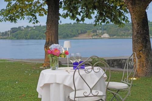 a table with a vase of flowers and wine glasses at Hotel Ristorante Lepanto in Salò