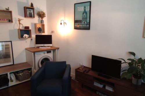 a living room with a tv and a couch and a chair at CŒUR MENOU, Radis'son & PARKING in Nantes