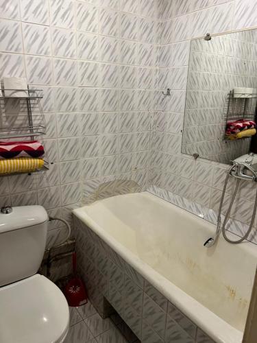 ein Badezimmer mit einer Badewanne, einem WC und einem Spiegel in der Unterkunft Guesthous in Narva