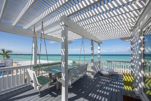 una pérgola blanca en una terraza con la playa en Caribbean SandCastle home, en James Cistern