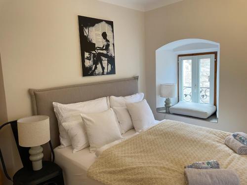 a bedroom with a bed with white pillows and a mirror at FREDYs APARTMENTs in Stari Grad