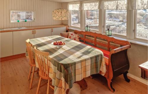 een keuken met een tafel met stoelen en een tafelkleed bij Awesome Home In Fjlkinge With Kitchen in Fjälkinge