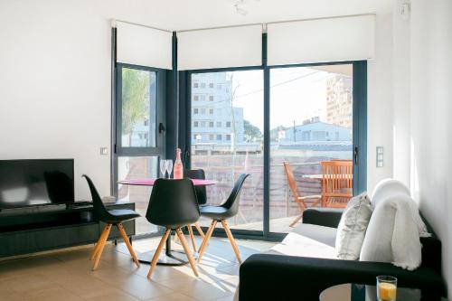 sala de estar con sofá y mesa con sillas en Moderno y confortable apartamento Port Trebol en Roses